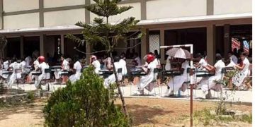 The teachers and principal are at odds, leaving the kids outside! Students have to take the exam in the sweltering sun! A few kids who took the test wearing helmets!