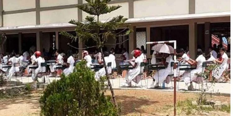 The teachers and principal are at odds, leaving the kids outside! Students have to take the exam in the sweltering sun! A few kids who took the test wearing helmets!